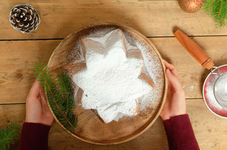 Pandoro - Italian christmas sweet yeast bread on festive served plate on wooden table.の写真素材