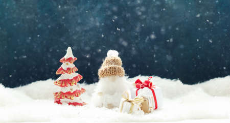 Funny gnome with Christmas decorations on a winter snowcovered background Xmas or New Year greeting card.の写真素材