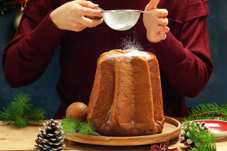 Pandoro - Italian christmas sweet yeast bread on festive served plate on wooden table.の写真素材