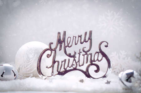 Merry Christmas silver text with decorations on a winter snowcovered background. Xmas or New Year greeting card.の写真素材