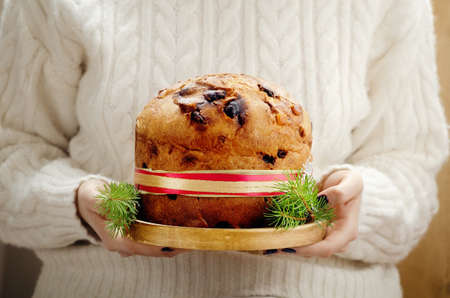 Panettone - Italian christmas sweet yeast bread on festive served plate on wooden table.の写真素材