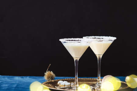 Winter cocktail with coconut flakes on gold tra. Christmas or New Year concept.の写真素材