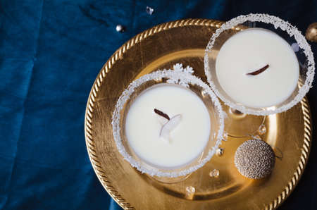 Winter cocktail with coconut flakes on gold tra. Christmas or New Year concept.の写真素材