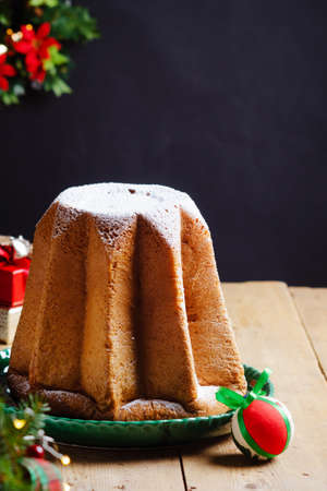 Italian Christmas sweet yeast bread - Pandoro on green ceramic plate on wooden table. With free text space.の写真素材