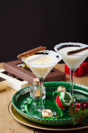 Winter cocktail with coconut flakes and cinnamon sticks on green tray. Christmas or New Year concept.の写真素材