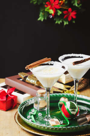 Winter cocktail with coconut flakes and cinnamon sticks on green tray. Christmas or New Year concept.の写真素材