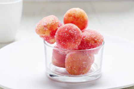 Italian carnival fritters drenched with Alchermes liqueur and sprinkled with sugar in glass bowl on...