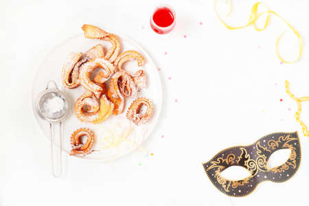 Italian carnival fritters galeno glove dusted with polwered sugar served on white plate.の写真素材