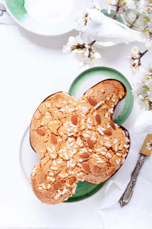 Colomba - italian easter dove cake on white green plate with spring flowers.の写真素材
