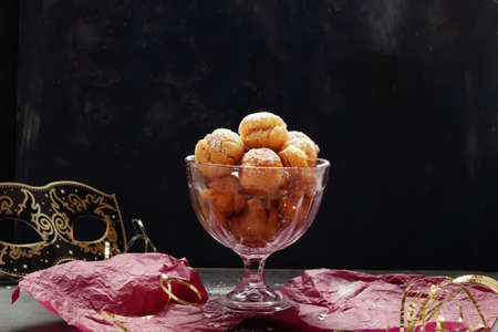 Italian carnival fritters dusted with powdered sugar in pink glass bowl. With free text space.の写真素材