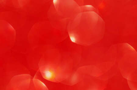 Abstract festive blurred red background texture with bokeh circles and lights for Valentine or wedding day. Card concept. Space for design.の写真素材