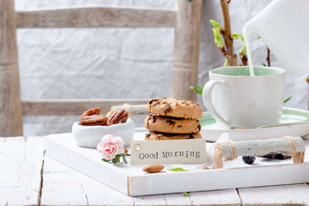 Cookies with chocolate chips and fresh berries for breakfast on white wooden table.の写真素材