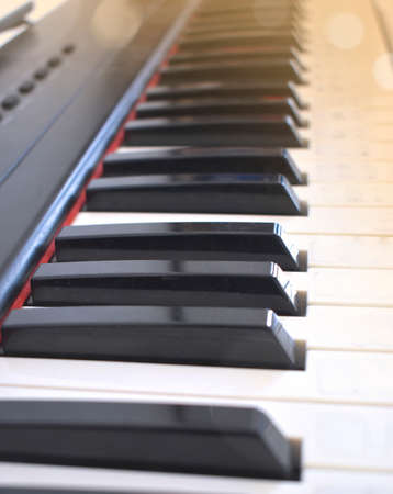 Close up piano keys on sunset light. Classic, jazz or electronical music concept. Frontal view with selective focus. Copyspace.の写真素材