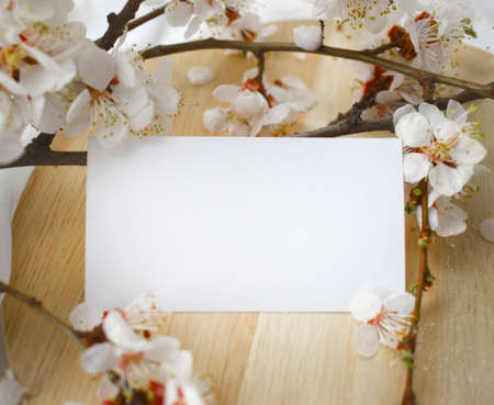Wedding invitation card with blooming branch on wooden background. Mock up greeting concept for Valentines day, Mothers day, Womans day.の写真素材