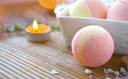 Still life spa resort treatment with bath bombs and candle on wooden background. Natural...