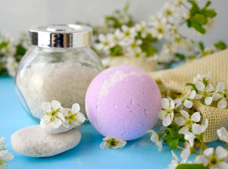Beautiful bodycare cosmetic composition with spa ball, sea salt and pebbles over spring blossom. Still life bath products concept.の写真素材