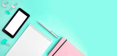 Feminine office flatlay with empty notepad, smartphone and stationery on mint background. Online education or blogging concept. Trendy design. ... Header with copy spaceの写真素材