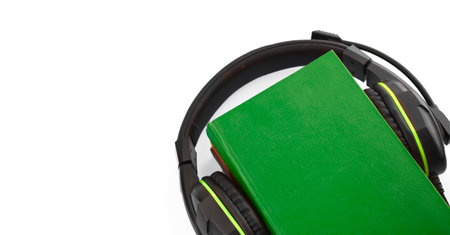 Audio book concept with headphones and stack of books on white background. E-learning. Listening to a book. Copyspace.の写真素材