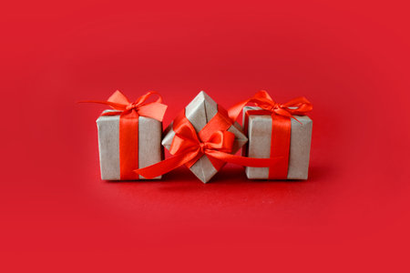 Close up composition with gifts on red background. Minimalist concept for Valentines day, Mothers day, Women day or wedding. Greeting card with copyspace.の写真素材