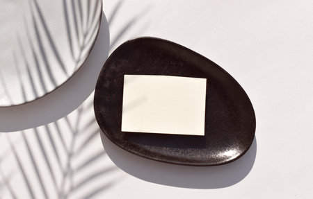 Summer tropical stationery still life scene with empty blank wedding card, handmade ceramic plate on...