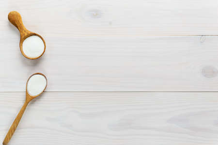 Collagen powder in spoons on a white wooden table. Dietary supplement. Horizontal orientation, top view, copy space.の写真素材
