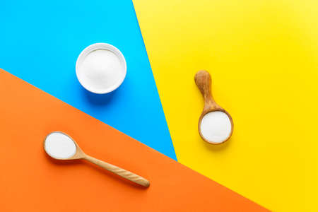 Collagen powder in a white bowl and spoons on a colorful background. Dietary supplement.の写真素材