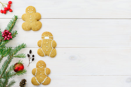 Gingerbread man in a mask on a wooden background. Horizontal orientation, copy space, top view.