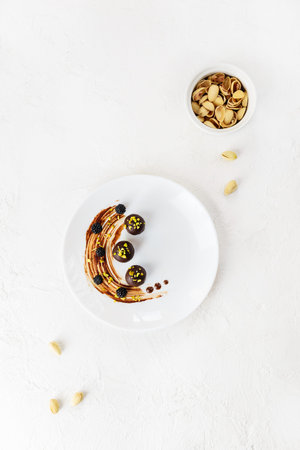 Homemade chocolates with nuts in a plate. Vertical orientation, top view.