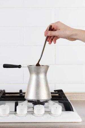 Turkish coffee on a gas stove, the preparation process. Fresh brewed coffee in turku. Vertical orientation.の写真素材