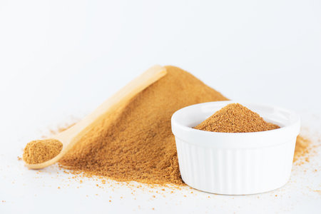 Unrefined cane sugar Panela in a bowl and a wooden spoon, Latin America food. Saccharum officinarum, Panela or sugar cane candy.の写真素材