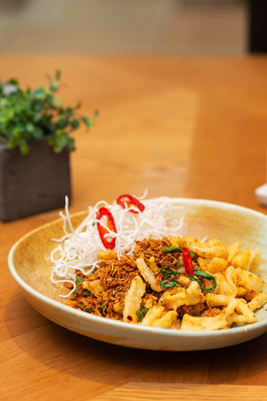 Fried squid with vegetables, chili and spices in a restaurant, Asian cuisine. Traditional Asian food. Vertical orientation, hard light.の写真素材