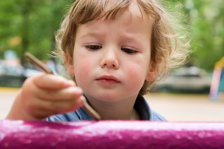 Child with pleasure paints a fenceの写真素材