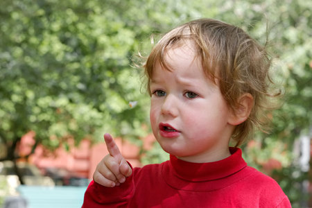 Boy makes warning gesture, having seen something unknown\r\n