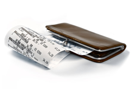 Cash receipt illustrating the spent money on background of a purse