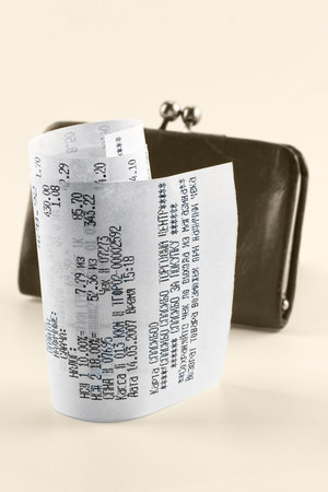 Cash receipt illustrating the spent money on background of a purse