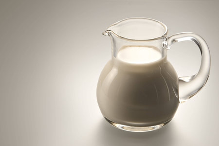 Jug with milk under soft illumination on a white backgroundの写真素材