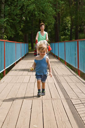 Happy mother and child go on the bridge forwardの写真素材