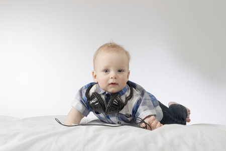 Little blond toddler with headphonesの写真素材