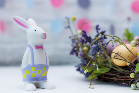 Funny Easter rabbit, colored eggs and flowers