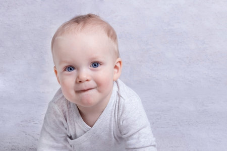 Adorable baby boy learning to crawl and playing. Cute laughing child crawling on a bed. Copy space.の写真素材
