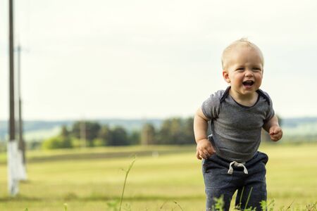 Funny running toddler against the blurred fieldの写真素材