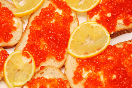 Backgrounf of bread and butter with red caviar and lemon.の写真素材