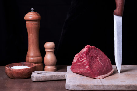 Raw fresh marbled meat Steak filet mignon and seasonings on black background. Ingredients for...