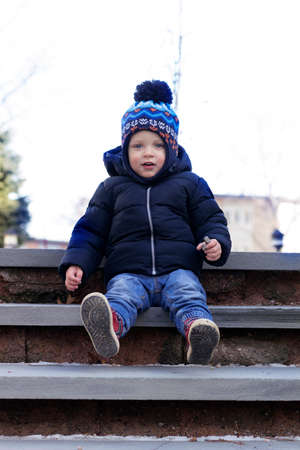 Funny 2 years toddler sitting on the concrete staircaseの写真素材