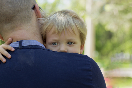Thoughtful little boy on fathers shoulder. Copy spaceの写真素材