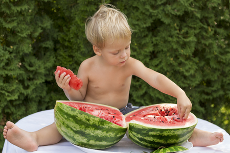 Cute baby boy Enjoy Eating The Watermelon on the green backgroundの写真素材