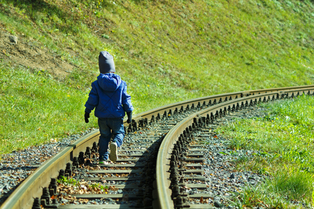 A young tourist is walking on a railroad track.の写真素材