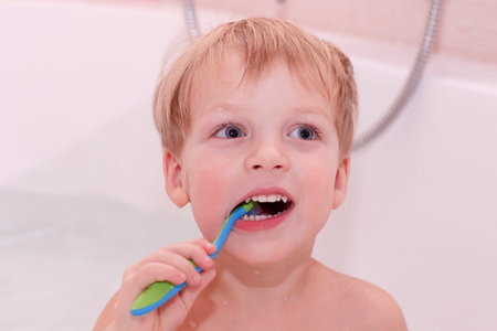 Adorable Baby boy cleaning teeth. Cute toddler with toothbrush in the bathの写真素材