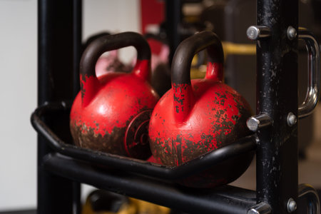 Close up of red kettlebells in a row at a gym. Sport equipment in fitness center.