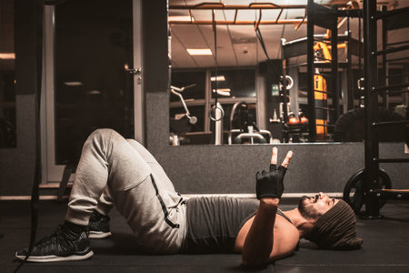 A bearded sporty man in the gym is doing relaxation of yoga and martial arts exercises. Yoga mental...